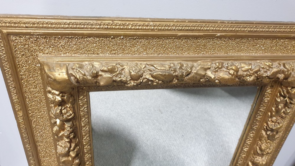 A matching pair of rectangular Victorian wall mirrors featuring ornate floral gesso moulding and a burnished gold finish. View III