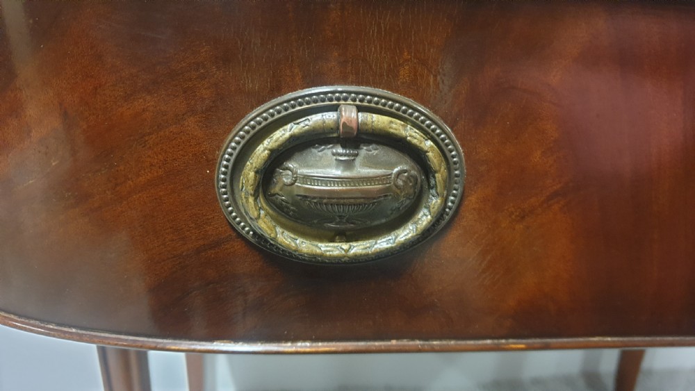 A small mahogany sideboard featuring a single curved drawer, brass ring handles, and fluted tapered legs. View VIII