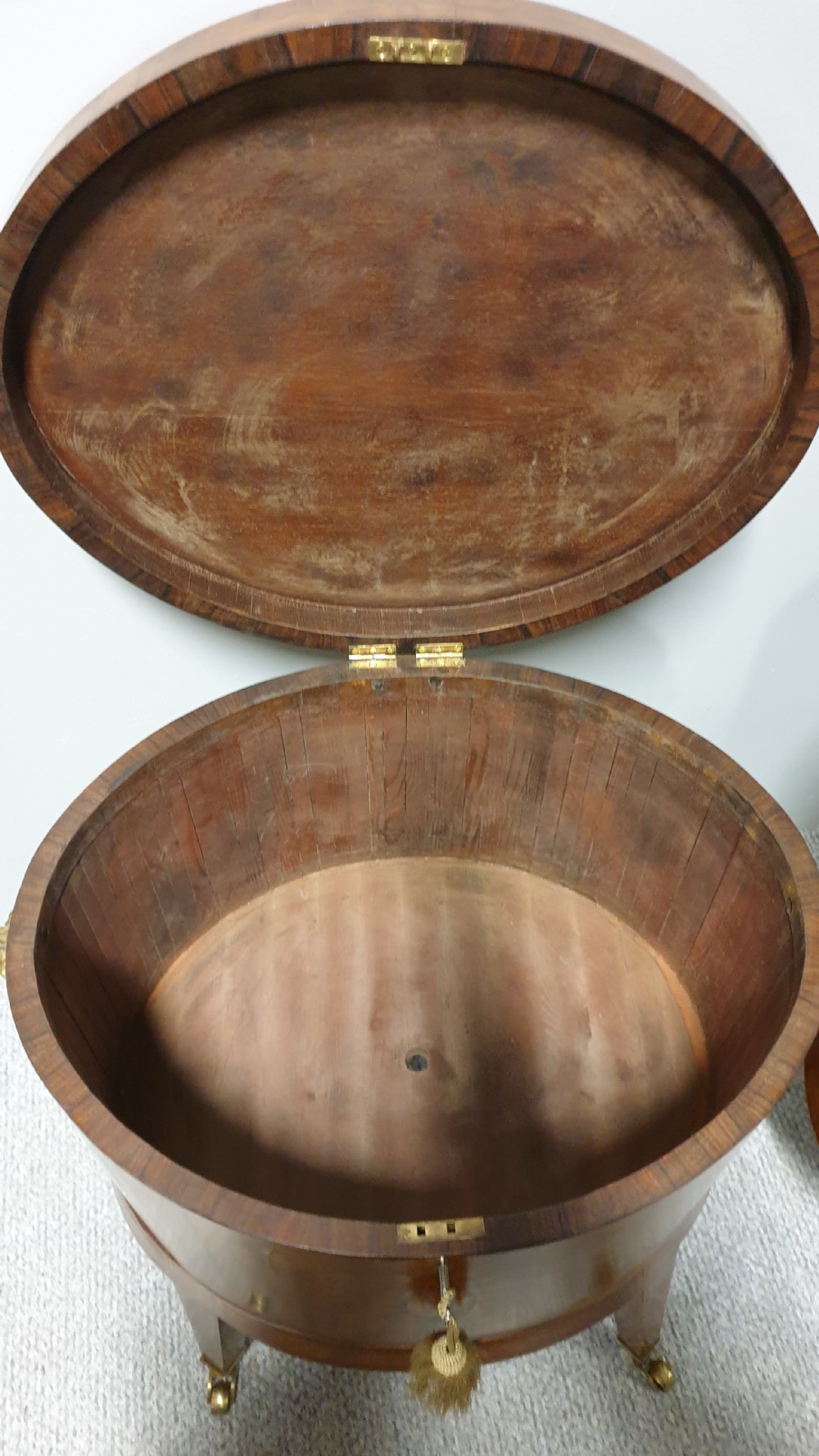 A pair of cylindrical satinwood wine coolers featuring inlaid marquetry oval medallions, lion mask brass side handles, key tassels, tapered legs, and brass castors. View XVI