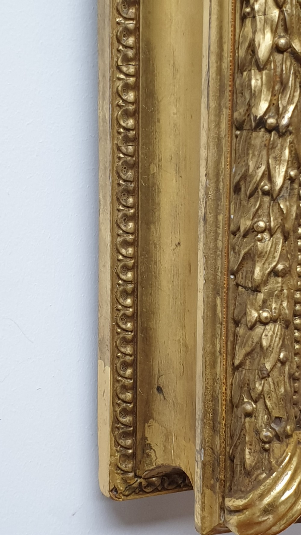 A rectangular antique wall mirror featuring a detailed gold giltwood frame with fluted moulding, leaf trim, and bevelled glass. View IX