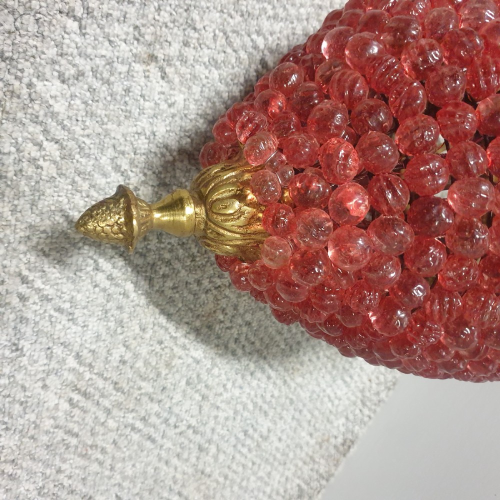 A gilt brass pendant chandelier featuring decorative leaf-motif chains and a teardrop-shaped shade formed of densely woven pink glass beads. View VII