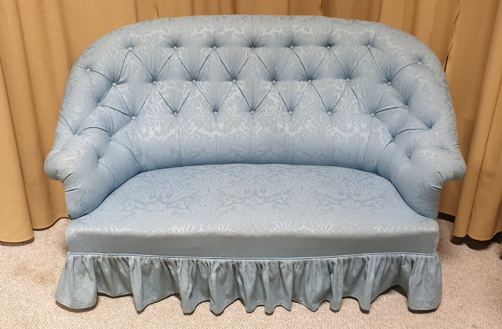 A light blue damask upholstered two-seater settee featuring deep buttoning across the backrest and a pleated base skirt. View II