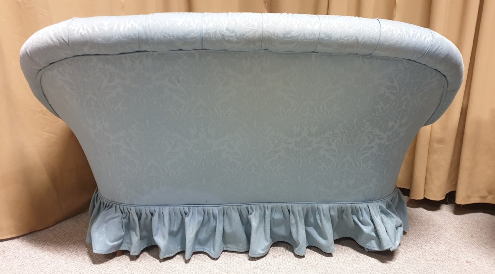 A light blue damask upholstered two-seater settee featuring deep buttoning across the backrest and a pleated base skirt. View XI