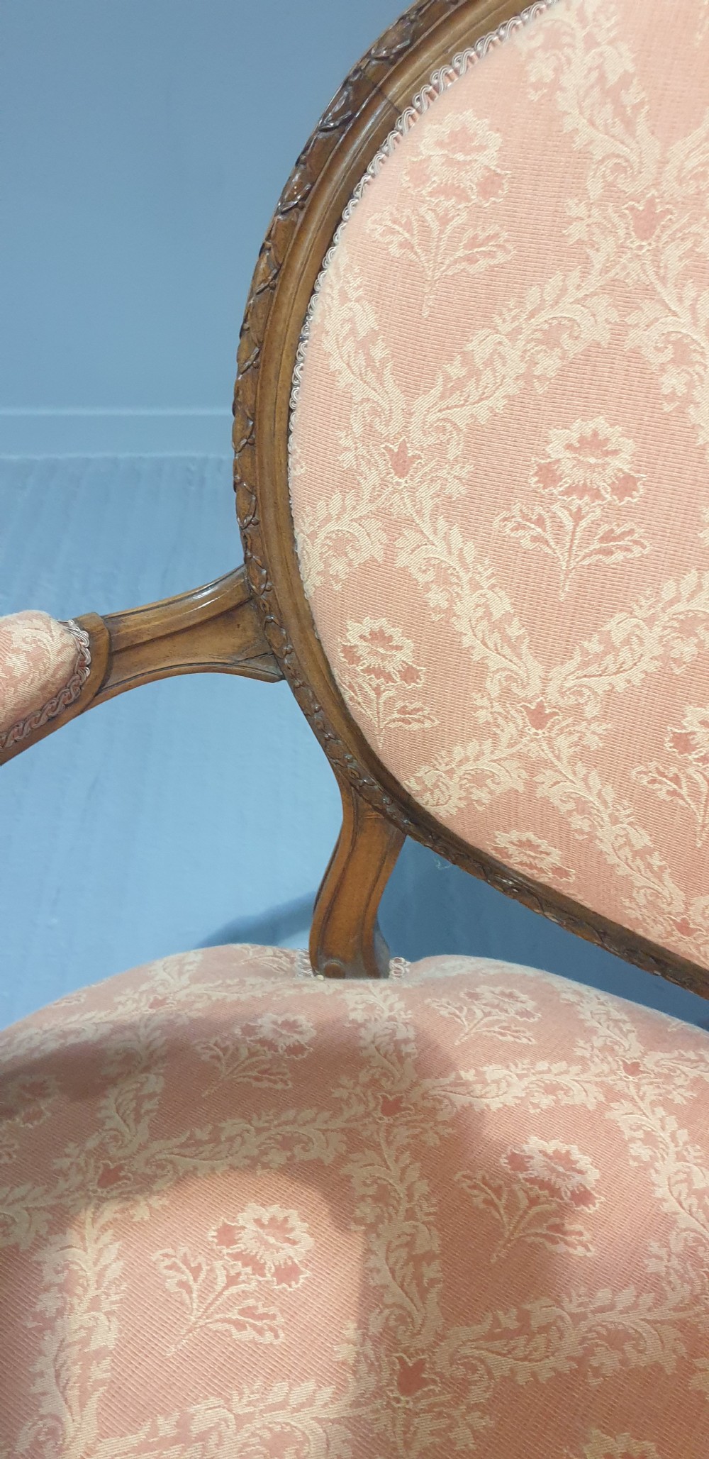 A Louis XVI style French walnut two-seat sofa featuring an oval upholstered backrest, carved timber frame, and turned fluted legs. View VII