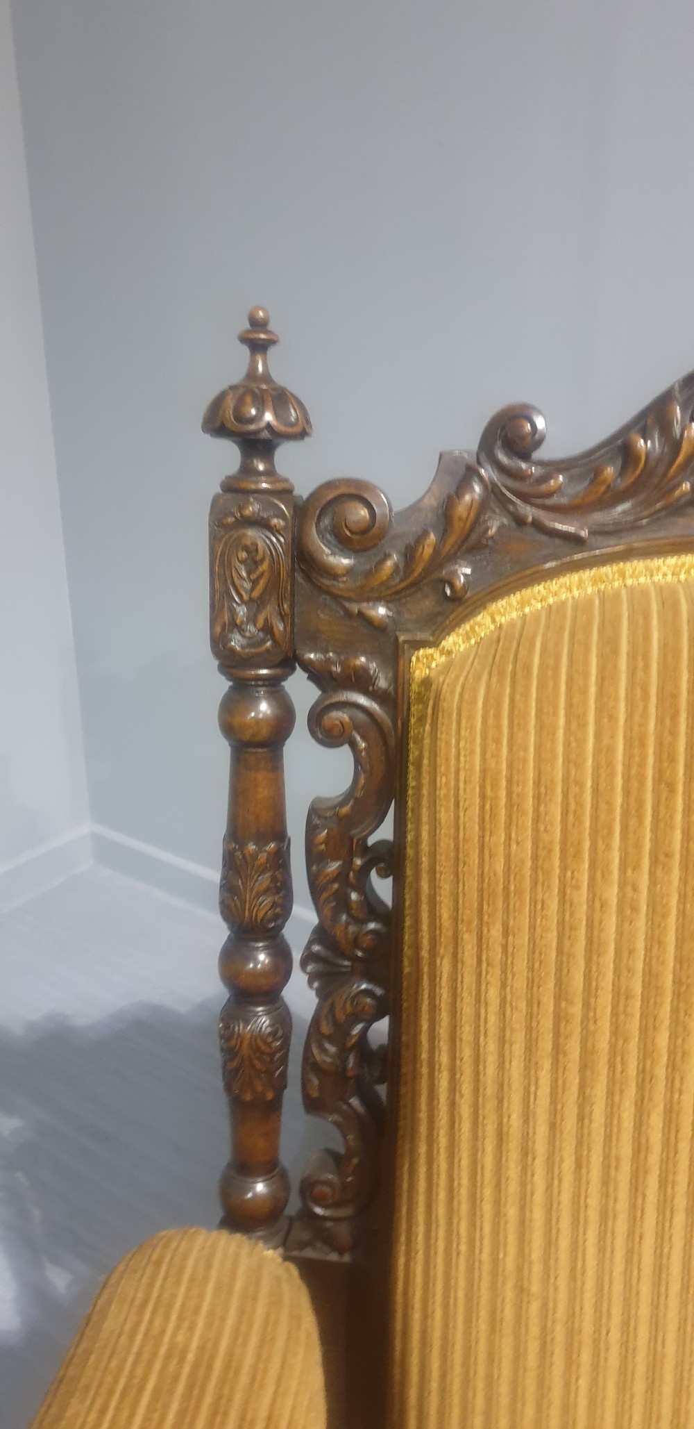 An antique double-backed sofa crafted from dark carved walnut wood with mustard yellow striped upholstery and fringe trim. View VIII