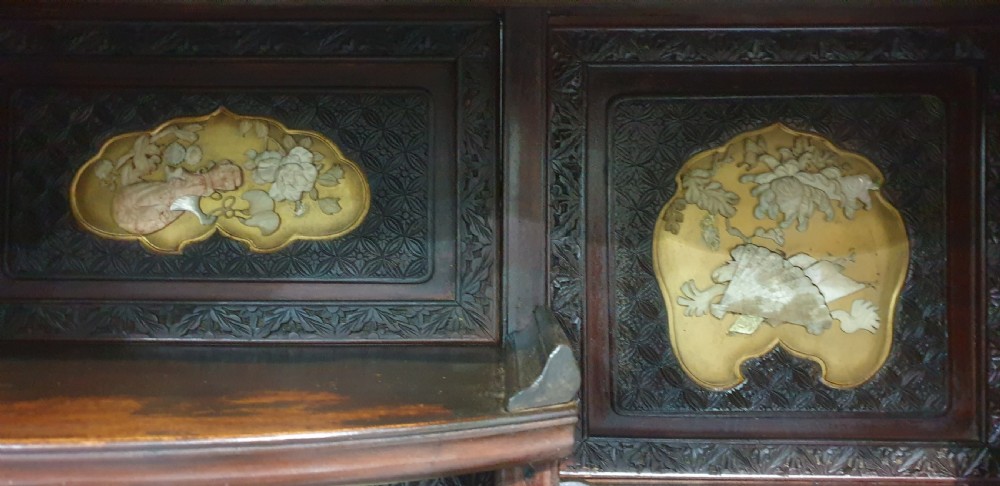 An intricately carved dark wood Japanese Meiji period Shibayama cabinet featuring multi-tiered asymmetrical shelves and gold lacquer panels inset with shell and bone motifs. View VI