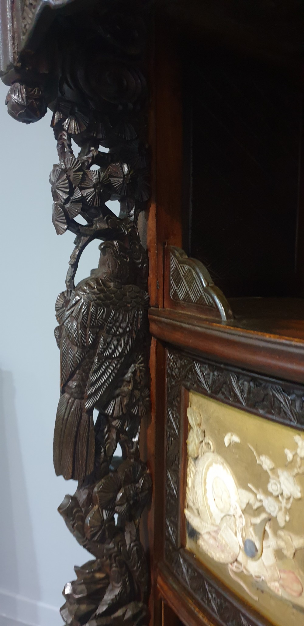 An intricately carved dark wood Japanese Meiji period Shibayama cabinet featuring multi-tiered asymmetrical shelves and gold lacquer panels inset with shell and bone motifs. View XI