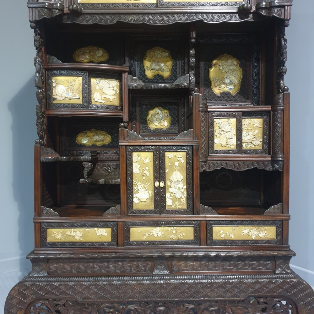 An intricately carved dark wood Japanese Meiji period Shibayama cabinet featuring multi-tiered asymmetrical shelves and gold lacquer panels inset with shell and bone motifs. View XVI