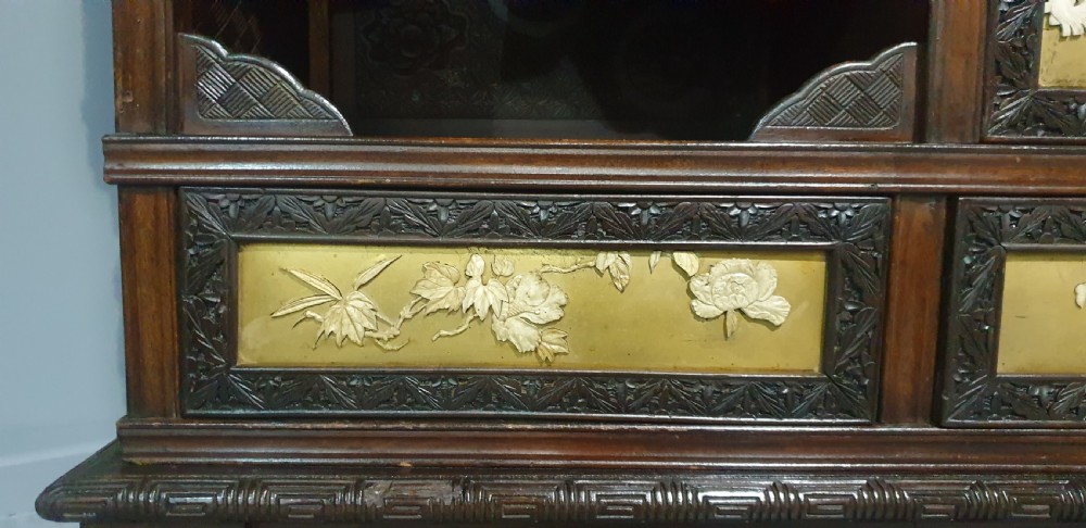 An intricately carved dark wood Japanese Meiji period Shibayama cabinet featuring multi-tiered asymmetrical shelves and gold lacquer panels inset with shell and bone motifs. View XXI