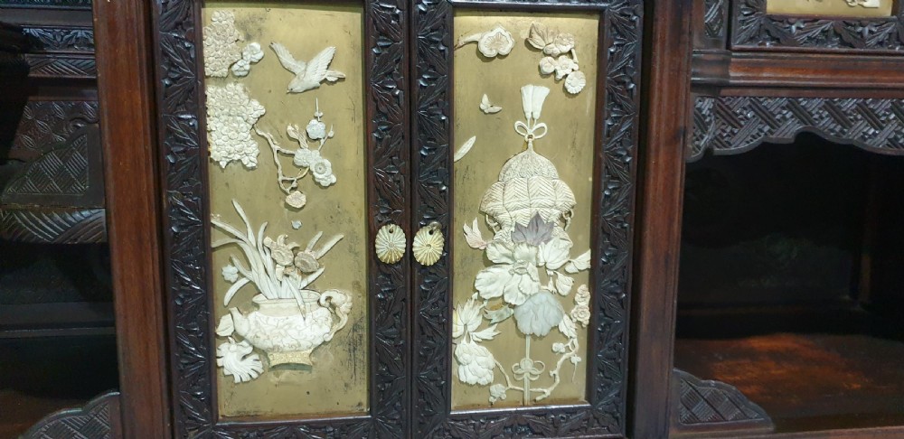 An intricately carved dark wood Japanese Meiji period Shibayama cabinet featuring multi-tiered asymmetrical shelves and gold lacquer panels inset with shell and bone motifs. View XXIII