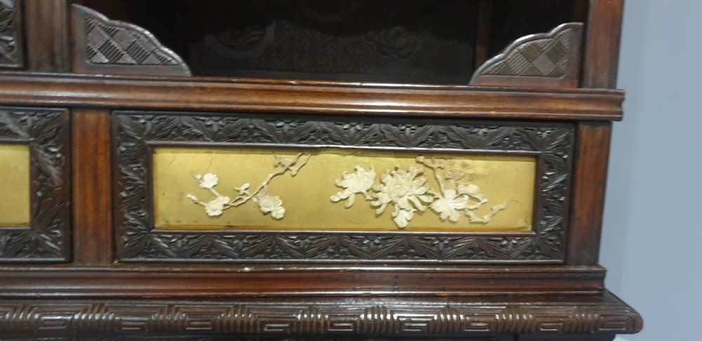 An intricately carved dark wood Japanese Meiji period Shibayama cabinet featuring multi-tiered asymmetrical shelves and gold lacquer panels inset with shell and bone motifs. View XXIV