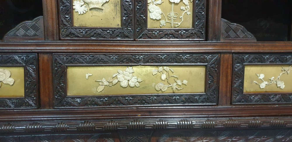 An intricately carved dark wood Japanese Meiji period Shibayama cabinet featuring multi-tiered asymmetrical shelves and gold lacquer panels inset with shell and bone motifs. View XXV