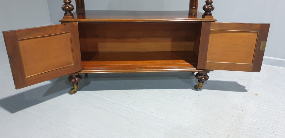A Victorian mahogany buffet server featuring a carved scroll splashback, turned columns, a two-door lower cupboard, and brass castors. View XI