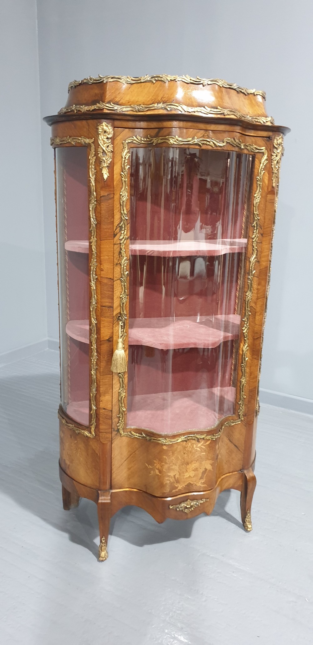 An antique French Louis XV style glazed vitrine display cabinet featuring curved glass sides, floral marquetry inlay, and detailed ormolu mounts. View II