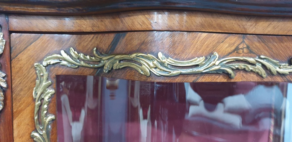An antique French Louis XV style glazed vitrine display cabinet featuring curved glass sides, floral marquetry inlay, and detailed ormolu mounts. View IX