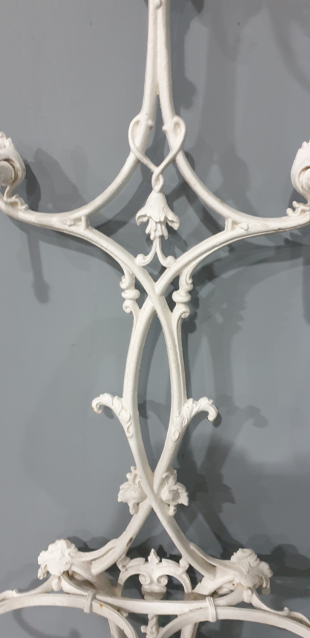 An ornate white painted cast iron hall stand featuring multiple coat hooks, scrollwork frame, umbrella support rings, and an integrated drip tray at the base. View VI