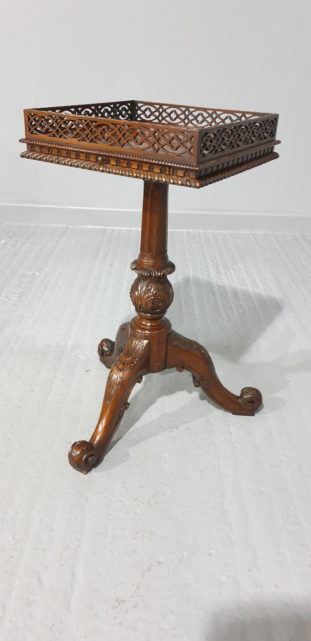 A mahogany tripod occasional table featuring a fretwork gallery top, a pull-out candle slide, a carved central column, and three carved legs. View III