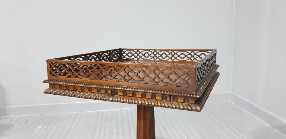A mahogany tripod occasional table featuring a fretwork gallery top, a pull-out candle slide, a carved central column, and three carved legs. View IV