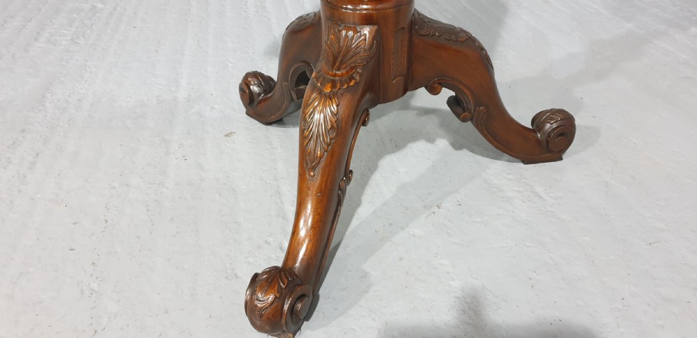 A mahogany tripod occasional table featuring a fretwork gallery top, a pull-out candle slide, a carved central column, and three carved legs. View VI
