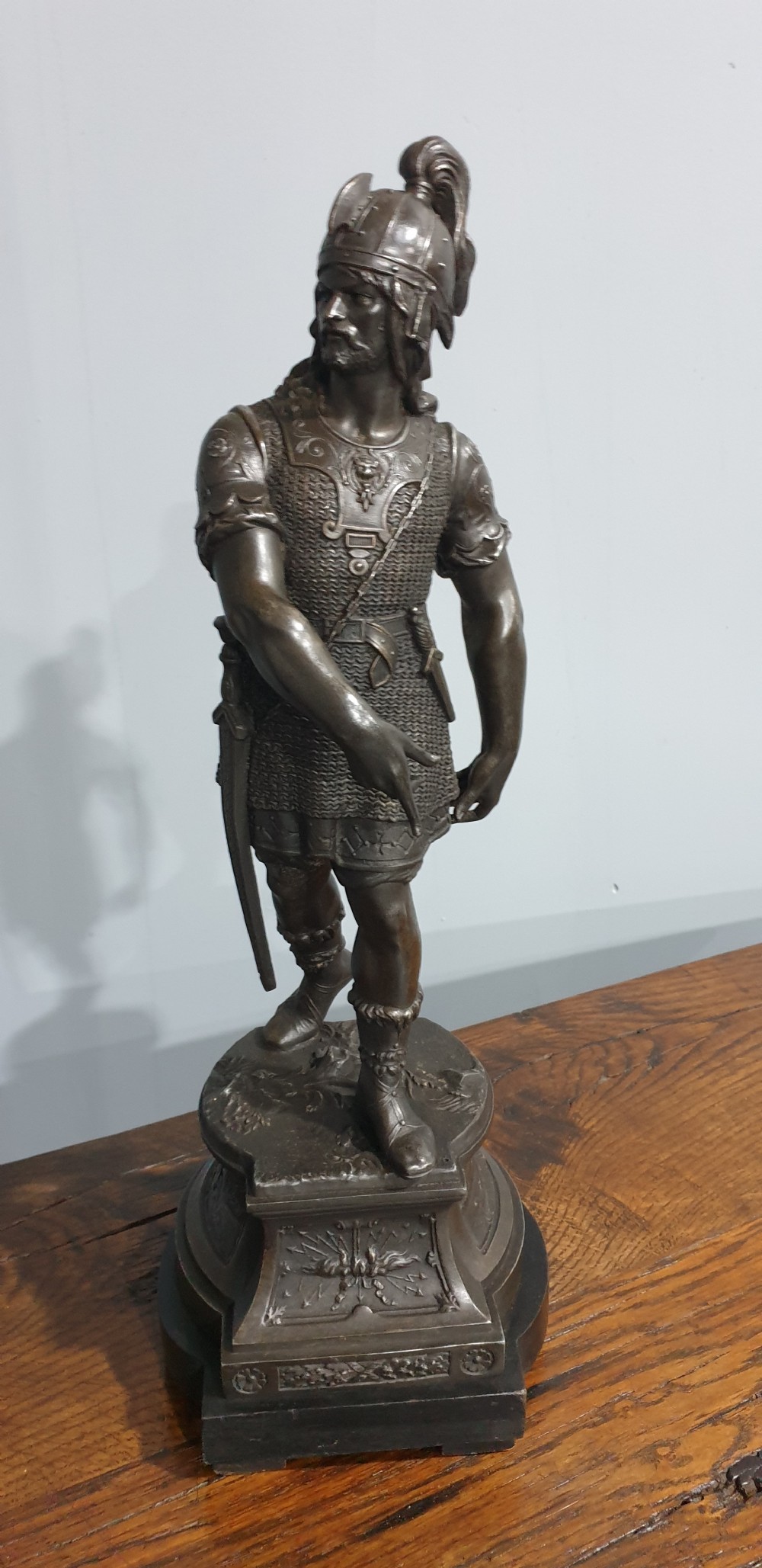 A pair of dark bronze-finished spelter statues depicting classical warriors wearing detailed armour and standing on relief-decorated bases. View II