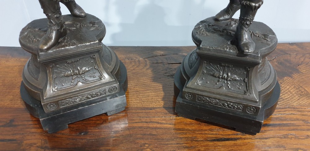A pair of dark bronze-finished spelter statues depicting classical warriors wearing detailed armour and standing on relief-decorated bases. View VIII