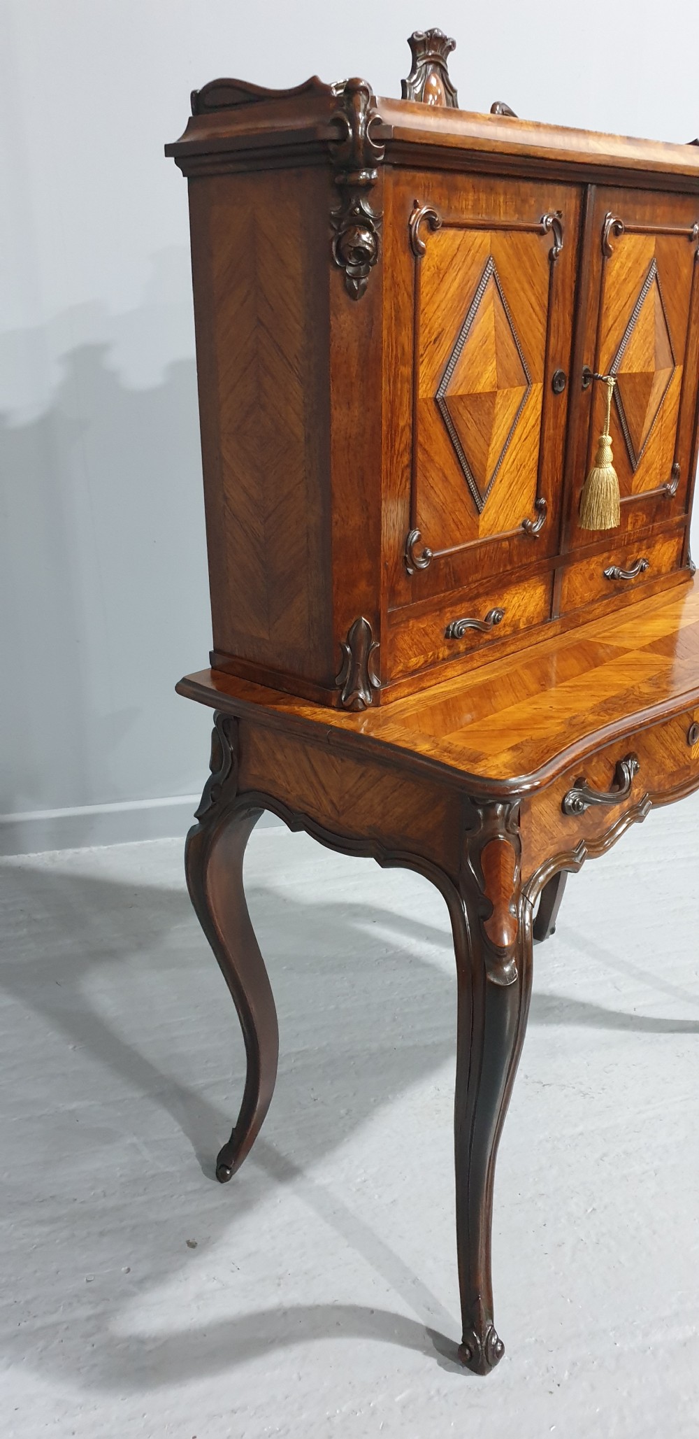 A French Bonheur du Jour writing desk in warm brown walnut with geometric diamond marquetry, cabriole legs, and an upper cabinet section with twin doors. View IV