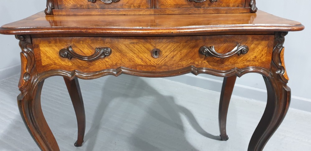 A French Bonheur du Jour writing desk in warm brown walnut with geometric diamond marquetry, cabriole legs, and an upper cabinet section with twin doors. View XI