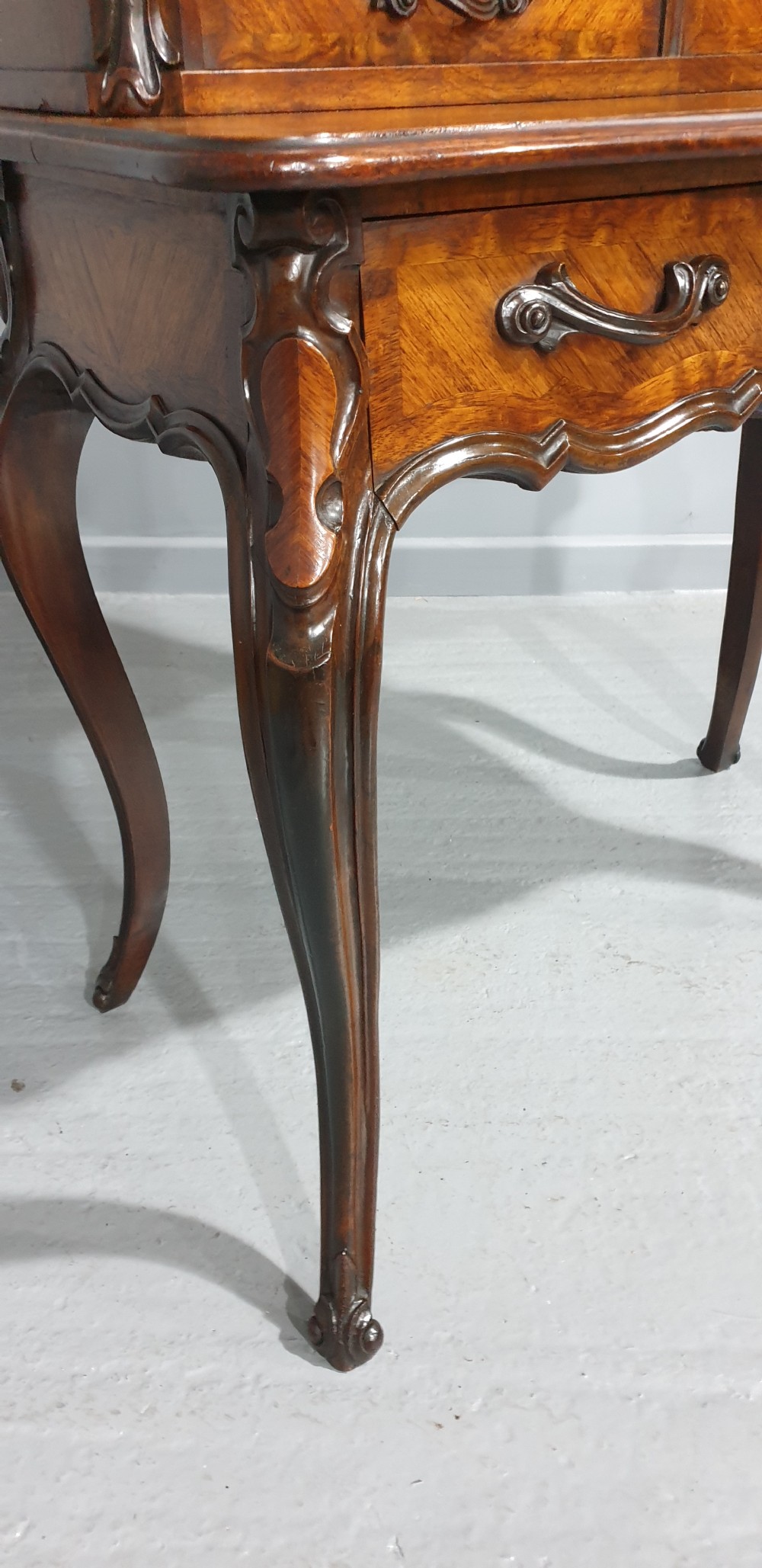 A French Bonheur du Jour writing desk in warm brown walnut with geometric diamond marquetry, cabriole legs, and an upper cabinet section with twin doors. View XII