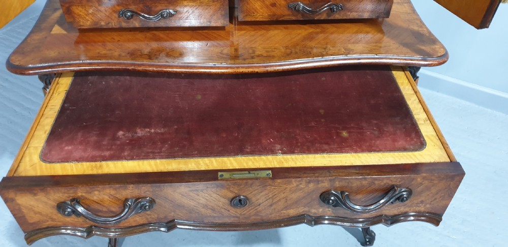 A French Bonheur du Jour writing desk in warm brown walnut with geometric diamond marquetry, cabriole legs, and an upper cabinet section with twin doors. View XVI