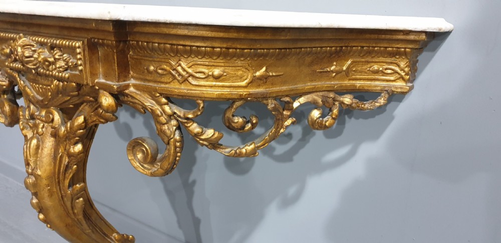 A 19th-century French giltwood wall-mounted console table featuring a single carved leg and a white marble top. View V