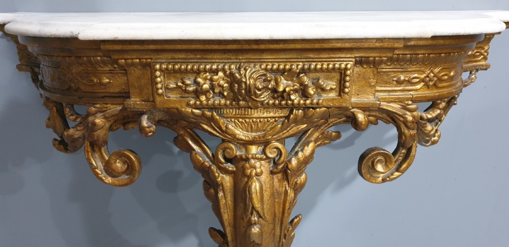 A 19th-century French giltwood wall-mounted console table featuring a single carved leg and a white marble top. View VI