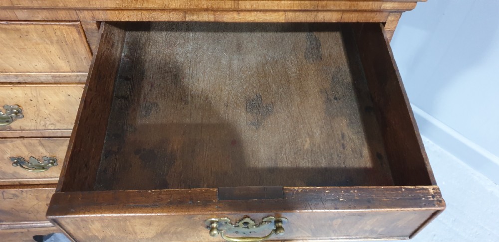 A George I walnut secretaire chest of small proportions featuring an upper double cabinet with arched door panels over a base of four drawers with brass hardware. View VIII