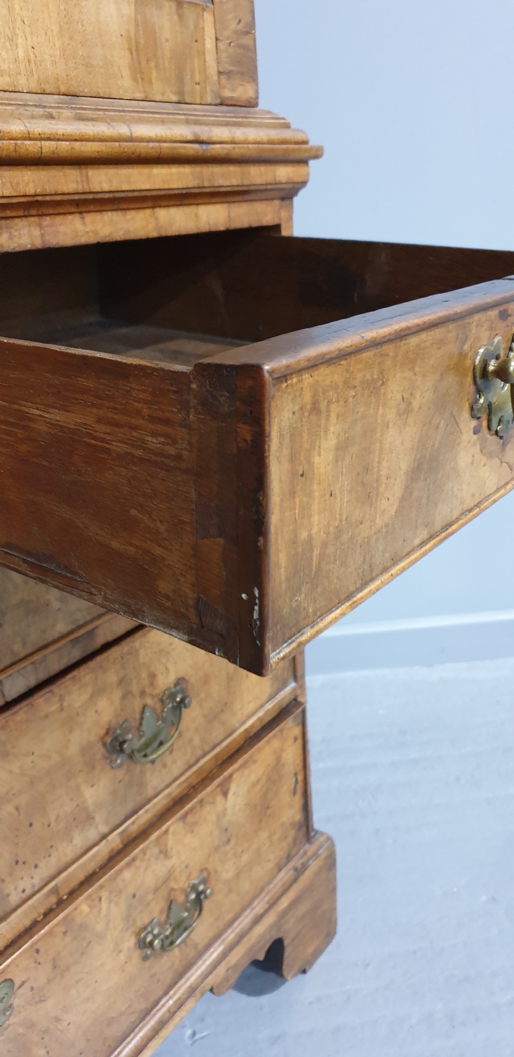 A George I walnut secretaire chest of small proportions featuring an upper double cabinet with arched door panels over a base of four drawers with brass hardware. View XI