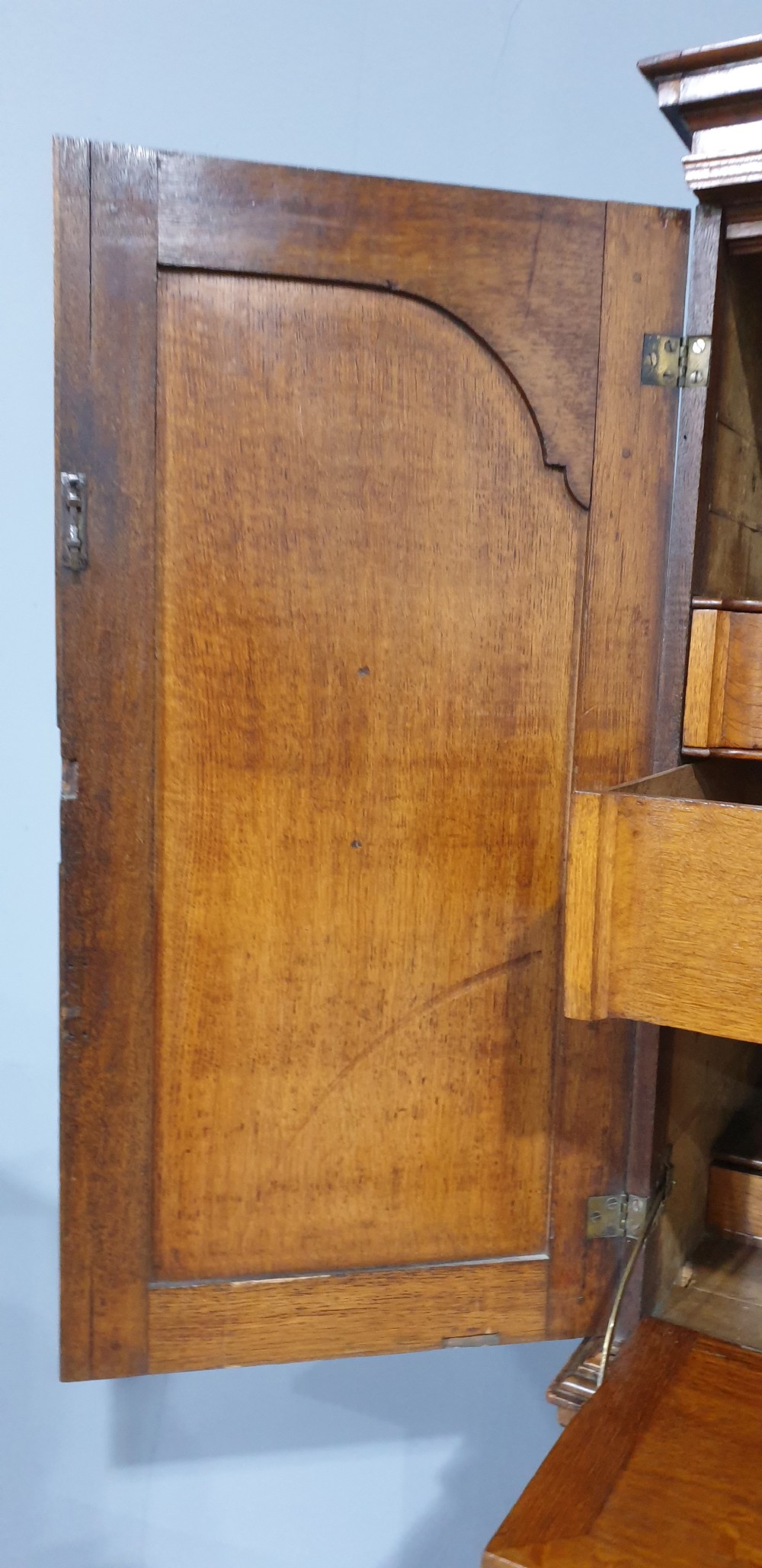 A George I walnut secretaire chest of small proportions featuring an upper double cabinet with arched door panels over a base of four drawers with brass hardware. View XVIII