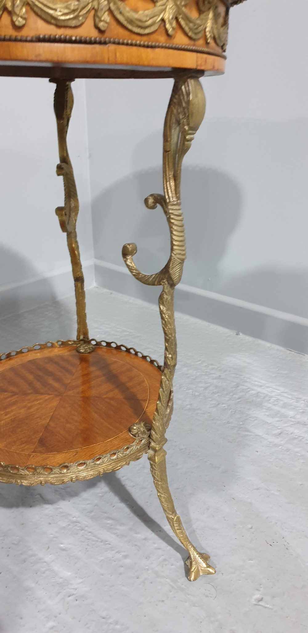 A round French side table featuring two tiers of sunburst parquetry veneer, decorative brass mounts, and a pierced gallery rim. View V