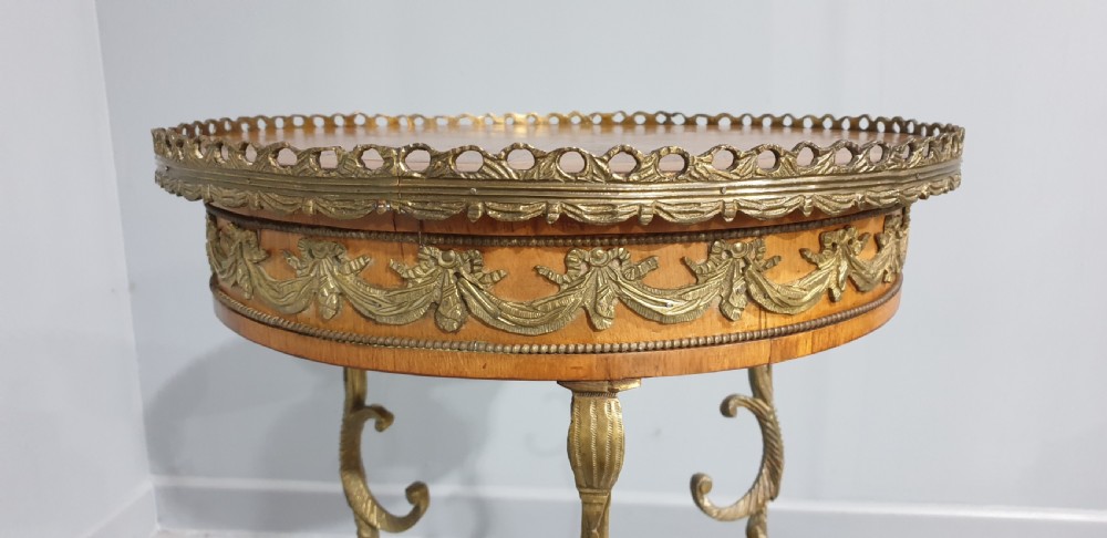A round French side table featuring two tiers of sunburst parquetry veneer, decorative brass mounts, and a pierced gallery rim. View IX