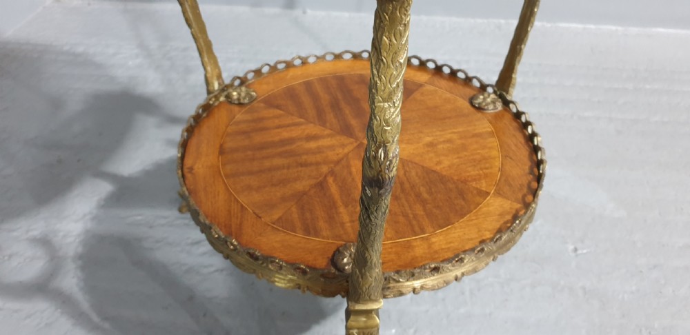 A round French side table featuring two tiers of sunburst parquetry veneer, decorative brass mounts, and a pierced gallery rim. View X