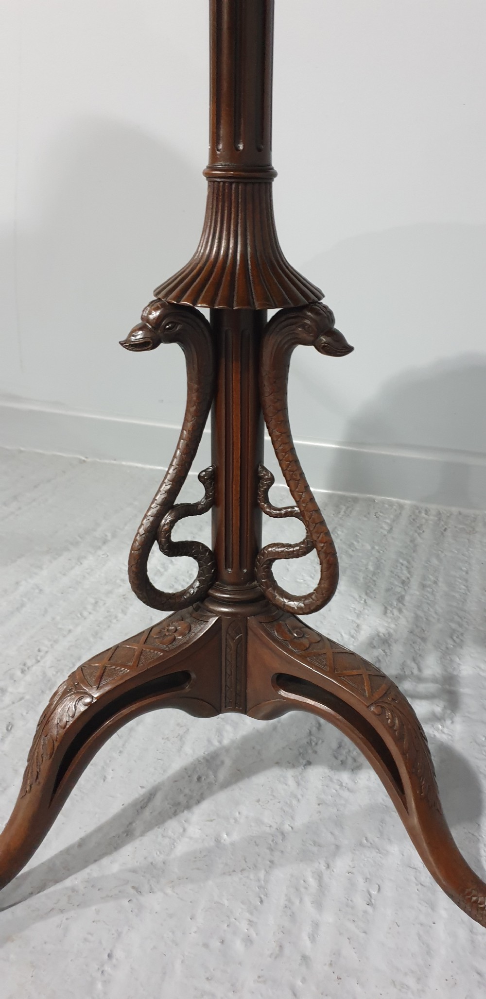 A mahogany tilt-top table with a pie-crust scalloped rim, resting on a carved tripod base with cabriole legs. View V
