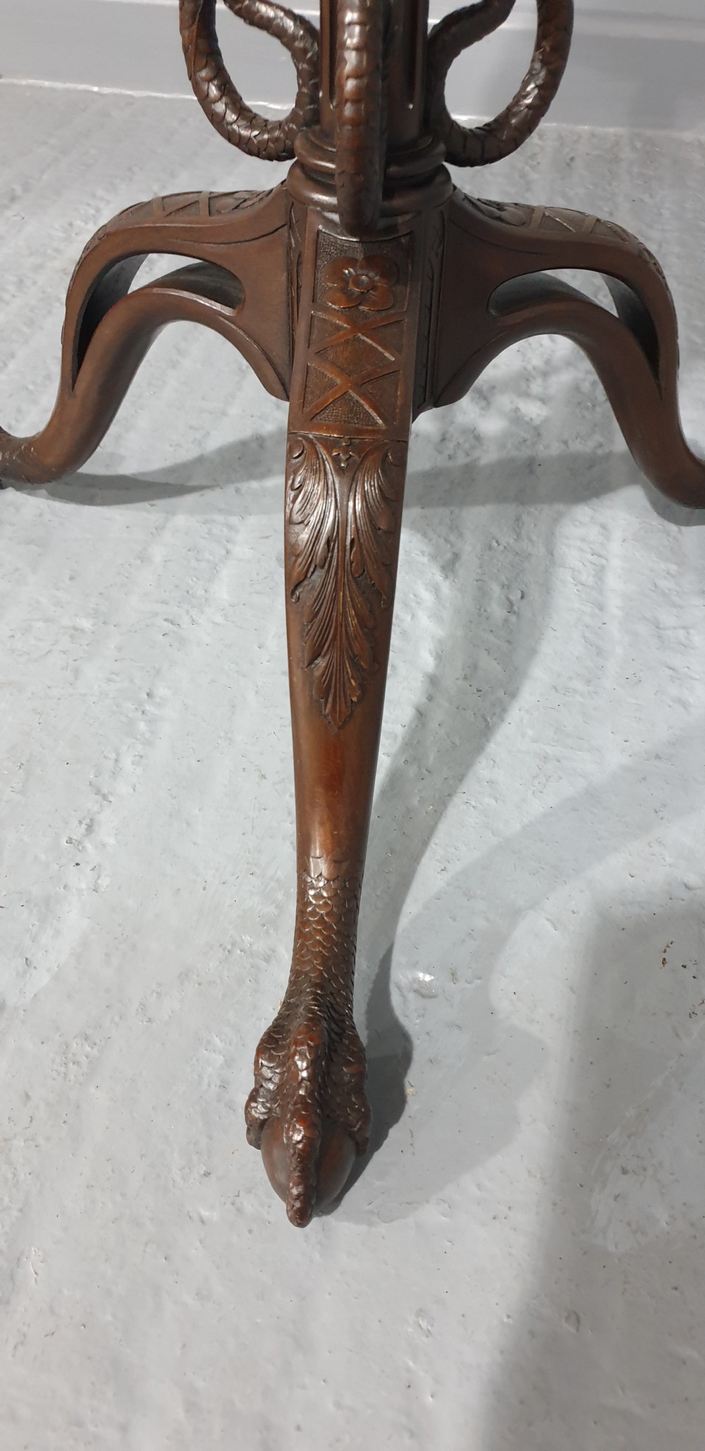 A mahogany tilt-top table with a pie-crust scalloped rim, resting on a carved tripod base with cabriole legs. View VII