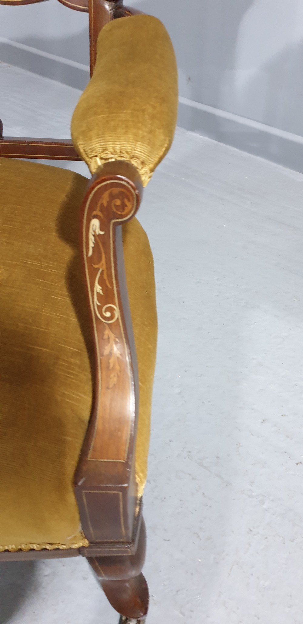 An Edwardian mahogany two-seat settee upholstered in button-tufted gold velvet with decorative marquetry inlays on the backrest and arm supports. View VI