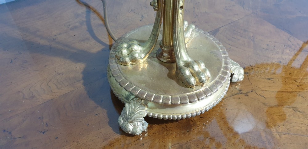 A pair of neoclassical gilded ormolu table lamps with slender cast metal bases and cream fabric shades decorated with tassel fringe. View IV