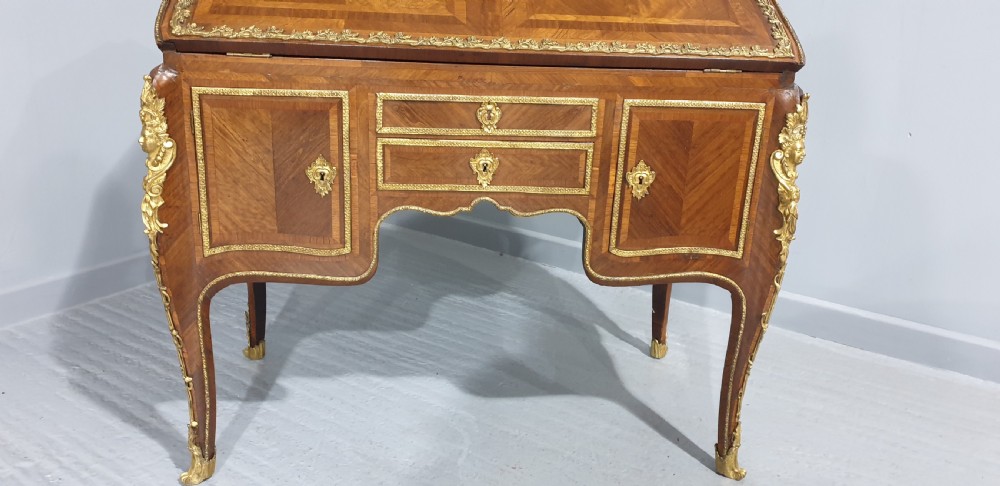 An early nineteenth-century French kingwood parquetry slant-front bureau featuring gilt-bronze ormolu mounts, cabriole legs, and geometric timber inlay. View IV