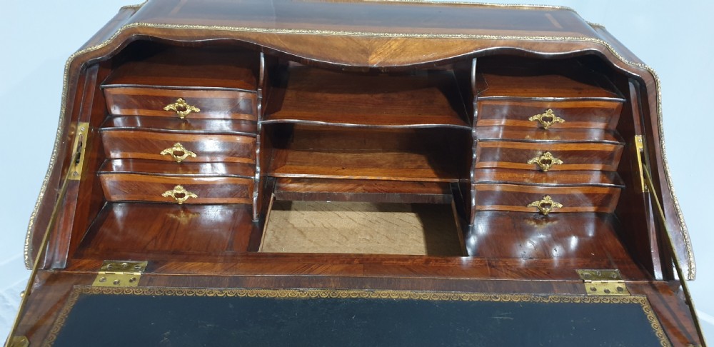 An early nineteenth-century French kingwood parquetry slant-front bureau featuring gilt-bronze ormolu mounts, cabriole legs, and geometric timber inlay. View V