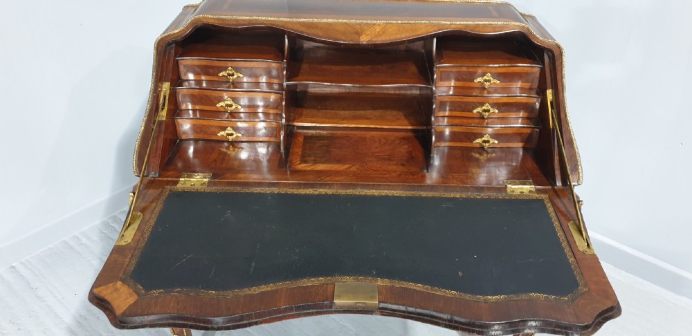An early nineteenth-century French kingwood parquetry slant-front bureau featuring gilt-bronze ormolu mounts, cabriole legs, and geometric timber inlay. View XI