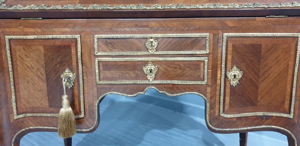 An early nineteenth-century French kingwood parquetry slant-front bureau featuring gilt-bronze ormolu mounts, cabriole legs, and geometric timber inlay. View XVII