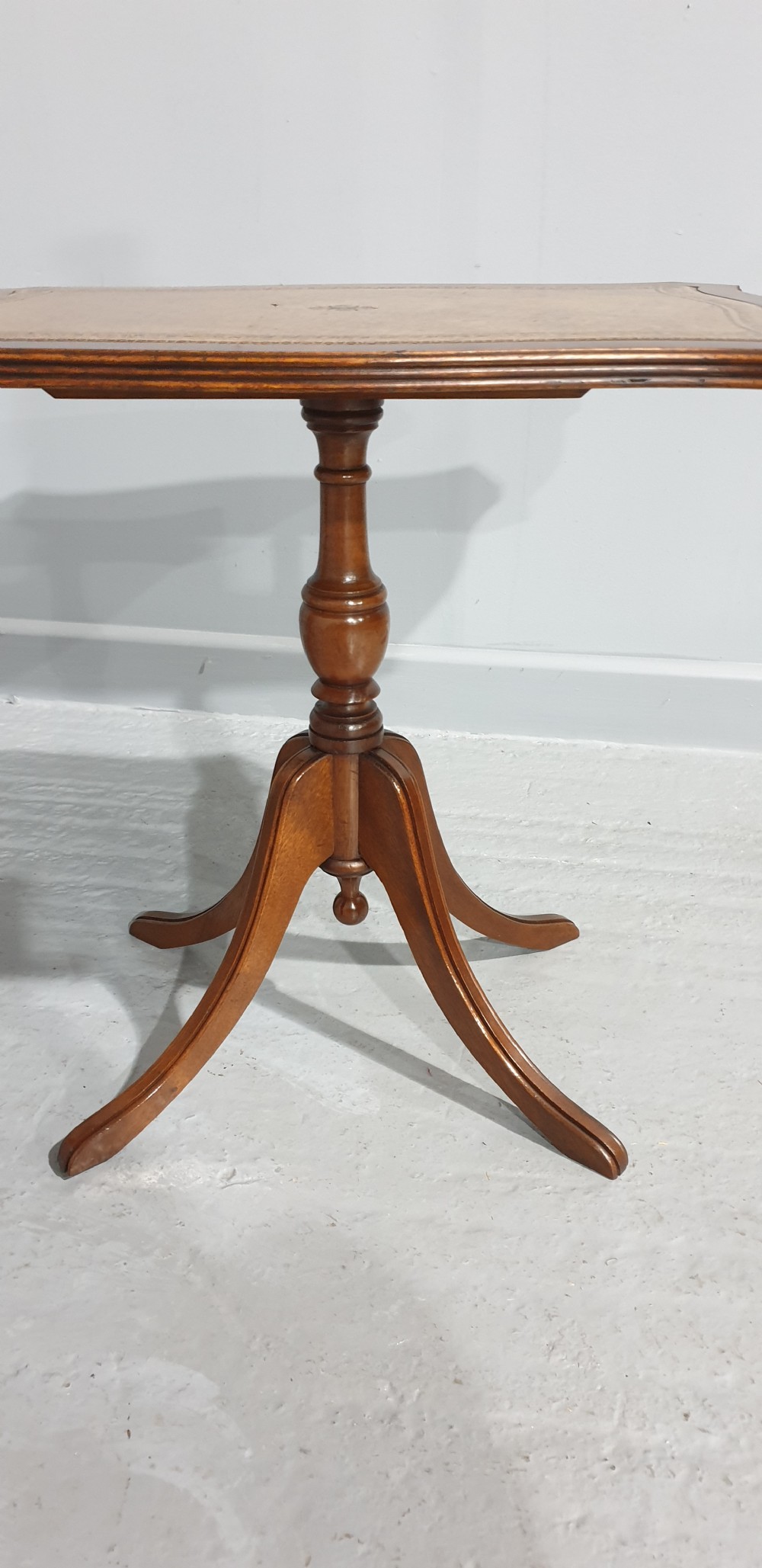A matching pair of mahogany pedestal wine tables featuring shaped tops with gold-tooled tan leather inserts and tripod cabriole legs. View III