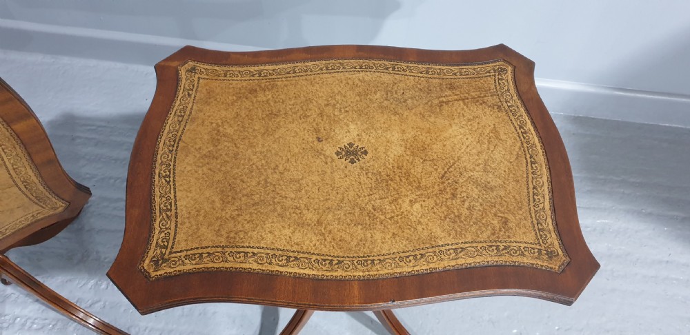 A matching pair of mahogany pedestal wine tables featuring shaped tops with gold-tooled tan leather inserts and tripod cabriole legs. View IV