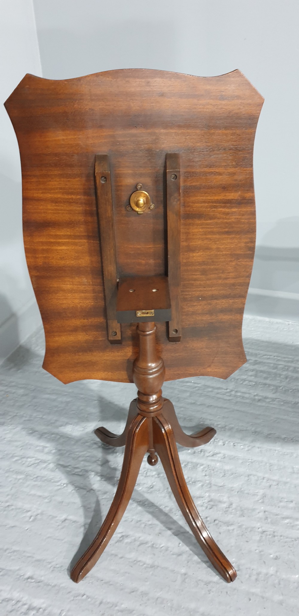 A matching pair of mahogany pedestal wine tables featuring shaped tops with gold-tooled tan leather inserts and tripod cabriole legs. View V