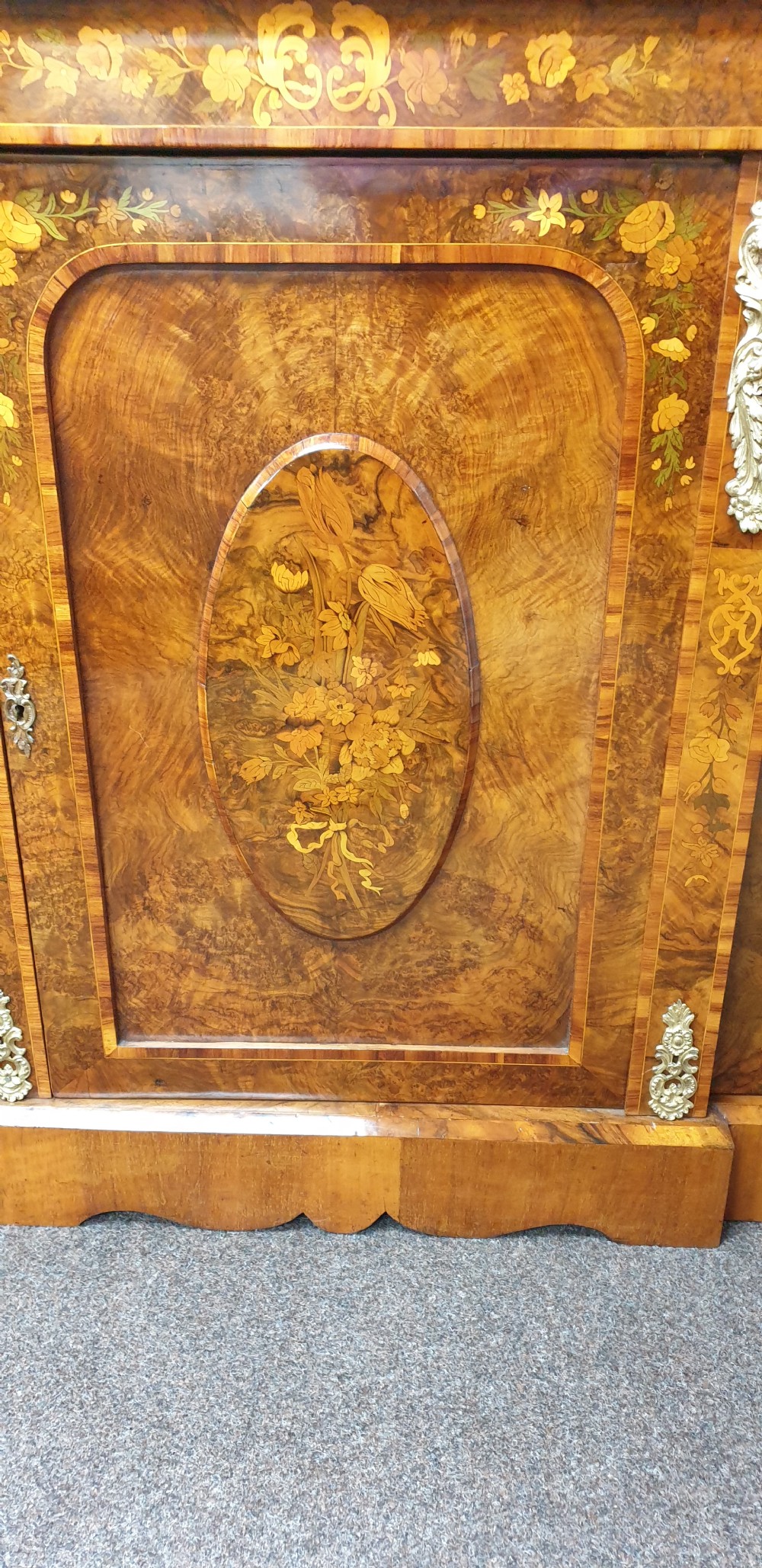 A low burr walnut and floral marquetry credenza bookcase featuring glazed side doors, a central solid panel door, and ornamental gilt-bronze mounts. View V