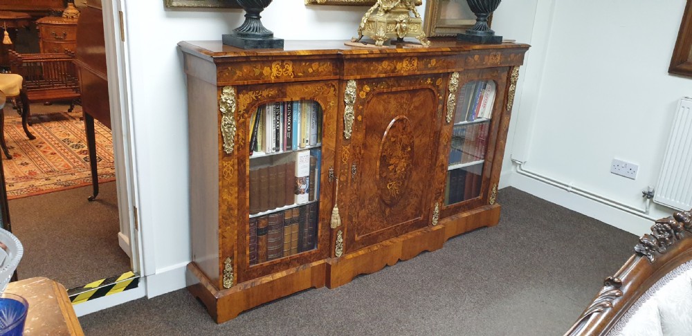 A low burr walnut and floral marquetry credenza bookcase featuring glazed side doors, a central solid panel door, and ornamental gilt-bronze mounts. View IX